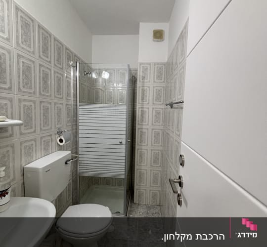 חדר אמבטיה עם מקלחון, כיור ואסלה